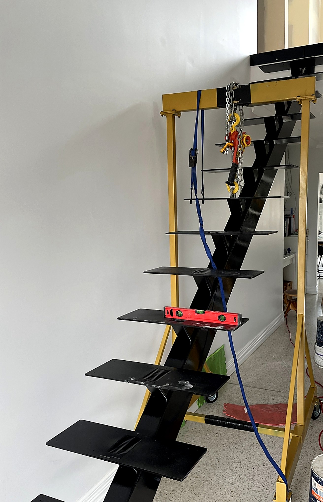 Black steel mono-stringer staircase being levelled during installation
